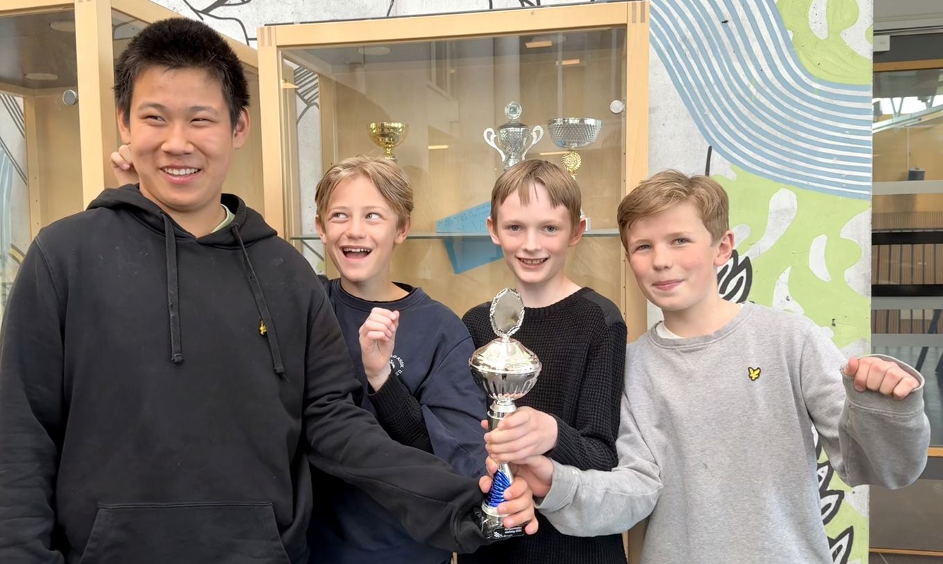 en gruppe mennesker som holder et trofé